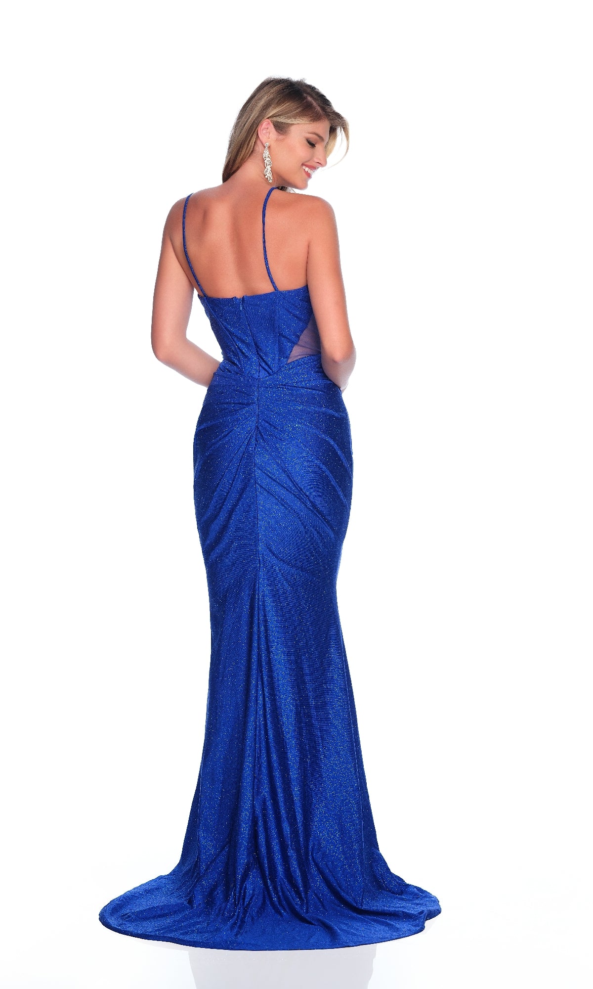 A woman models the Dave & Johnny 12252 Royal Blue Glitter Prom Dress, a fitted, floor-length gown with thin straps and sparkling glitter jersey fabric, shown from the back against a white background.